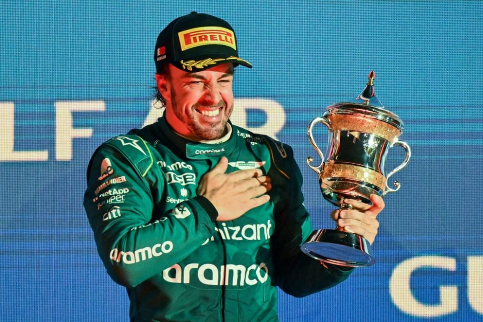 TOPSHOT - Aston Martin's Spanish driver Fernando Alonso celebrates on the podium with the third