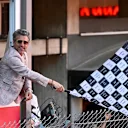 Patrick Dempsey waves the chequered flag at the end of the Grand Prix