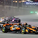 SINGAPORE, SINGAPORE - OCTOBER 05: Lando Norris of Great Britain driving the (4) McLaren MCL39 Mercedes and Oscar Piastri of Australia driving the (81) McLaren MCL39 Mercedes battle for track position at the start during the F1 Grand Prix of Singapore at Marina Bay Street Circuit on October 05, 2025 in Singapore, Singapore. (Photo by Bryn Lennon/Getty Images)