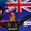 SINGAPORE, SINGAPORE - OCTOBER 05: Race winner George Russell of Great Britain and Mercedes AMG Petronas F1 Team celebrates on the podium with his trophy during the F1 Grand Prix of Singapore at Marina Bay Street Circuit on October 05, 2025 in Singapore, Singapore. (Photo by Clive Rose - Formula 1/Formula 1 via Getty Images)