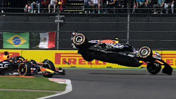 TOPSHOT - Red Bull Racing's Mexican driver Sergio Perez (R) crashes during the start of the Formula