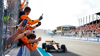 Lando Norris, McLaren MCL38, 1st position, crosses the line to cheers from his team on the pit wall