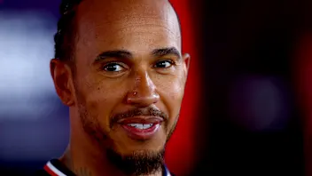 Mercedes' British driver Lewis Hamilton looks on in the stand during the first practice session at