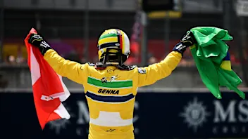 IMOLA, ITALY - MAY 19: Sebastian Vettel holds an Austrian and Brazilian flag in tribute to Roland
