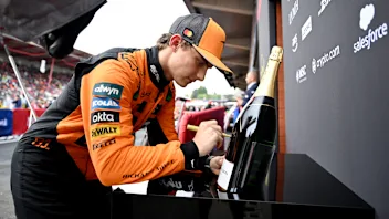 SPA, BELGIUM - JULY 27: Race winner Oscar Piastri of Australia and McLaren signs a Champagne bottle