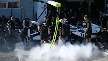 SPIELBERG, AUSTRIA - JUNE 26: Cadillac F1 Team personnel extinguish a fire on the car of Sergio