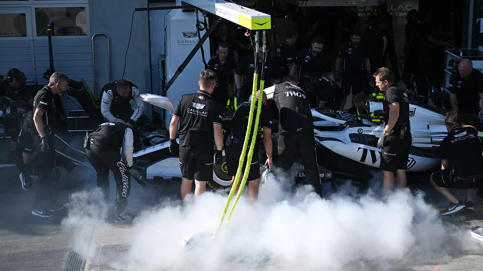 SPIELBERG, AUSTRIA - JUNE 26: Cadillac F1 Team personnel extinguish a fire on the car of Sergio