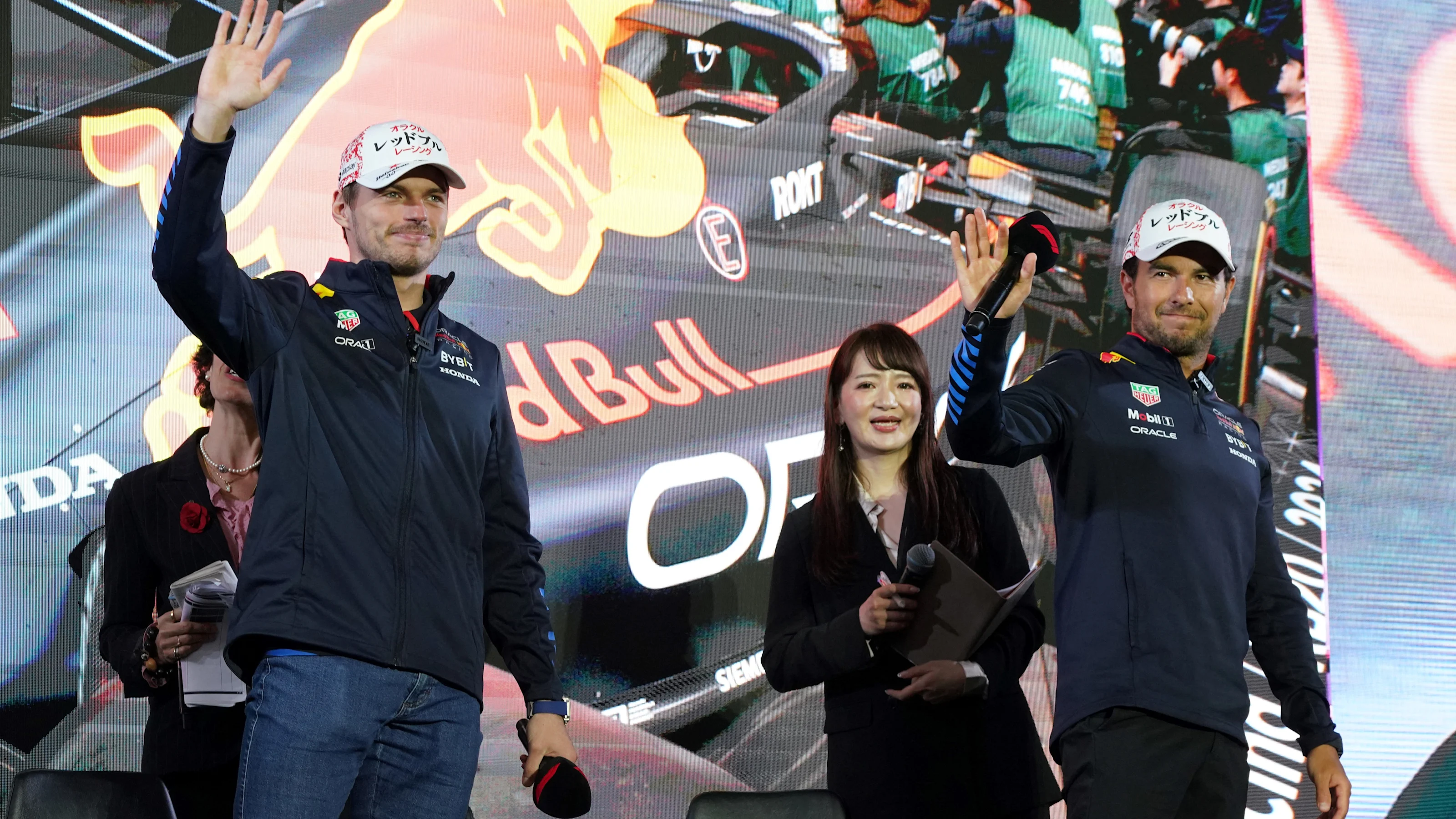 Red Bull Racing's Dutch driver Max Verstappen (L) and Mexican teammate Sergio Perez (R) wave to