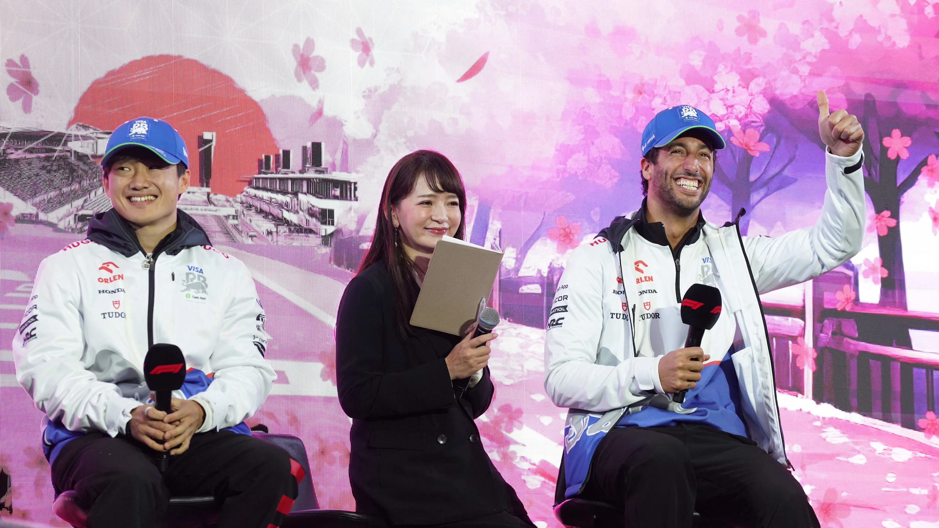 RB's Japanese driver Yuki Tsunoda (L) and his Australian teammate Daniel Ricciardo (R) attend a