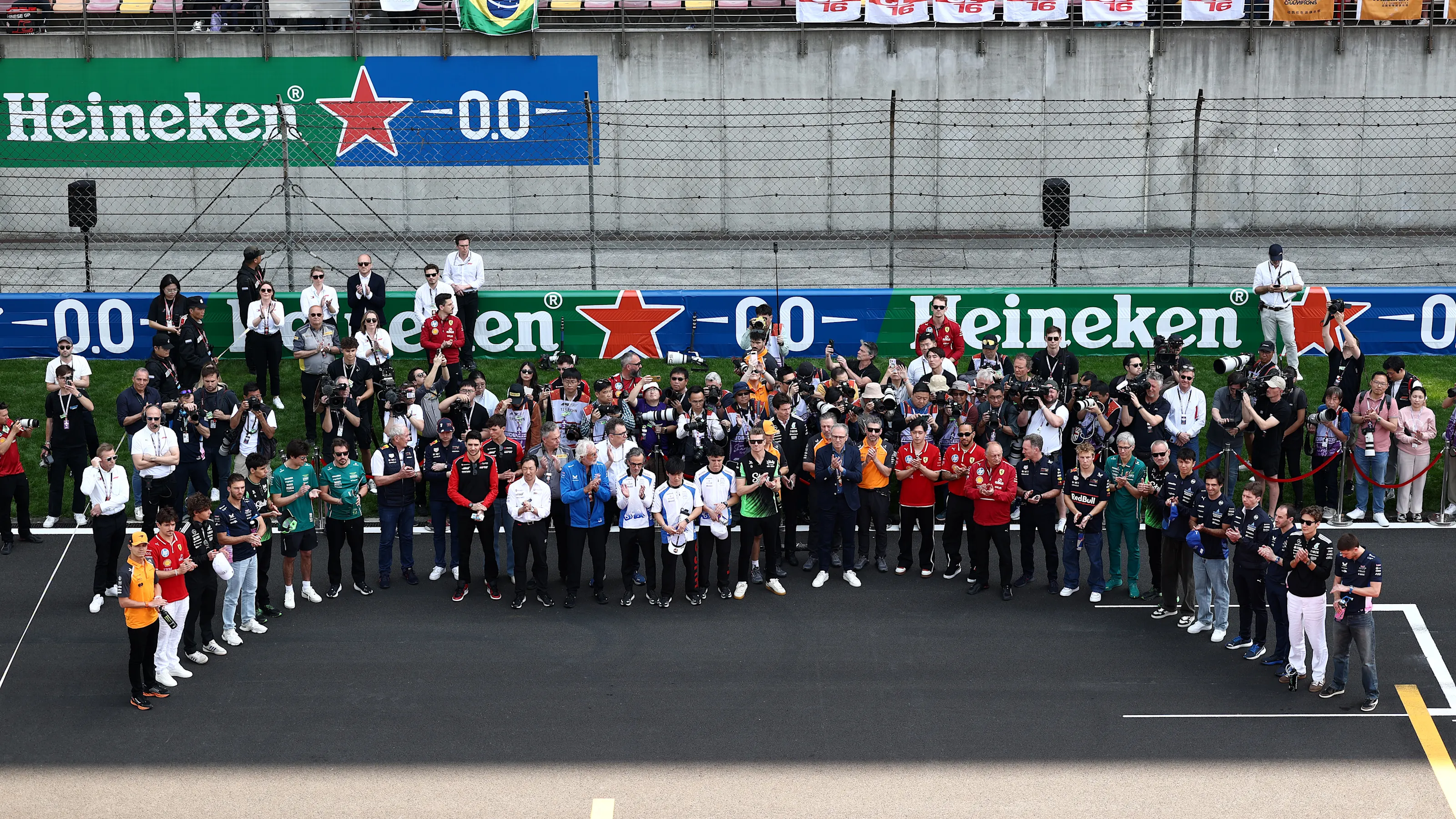 SHANGHAI, CHINA - MARCH 23: Drivers and team personnel gather in tribute to the late Eddie Jordan