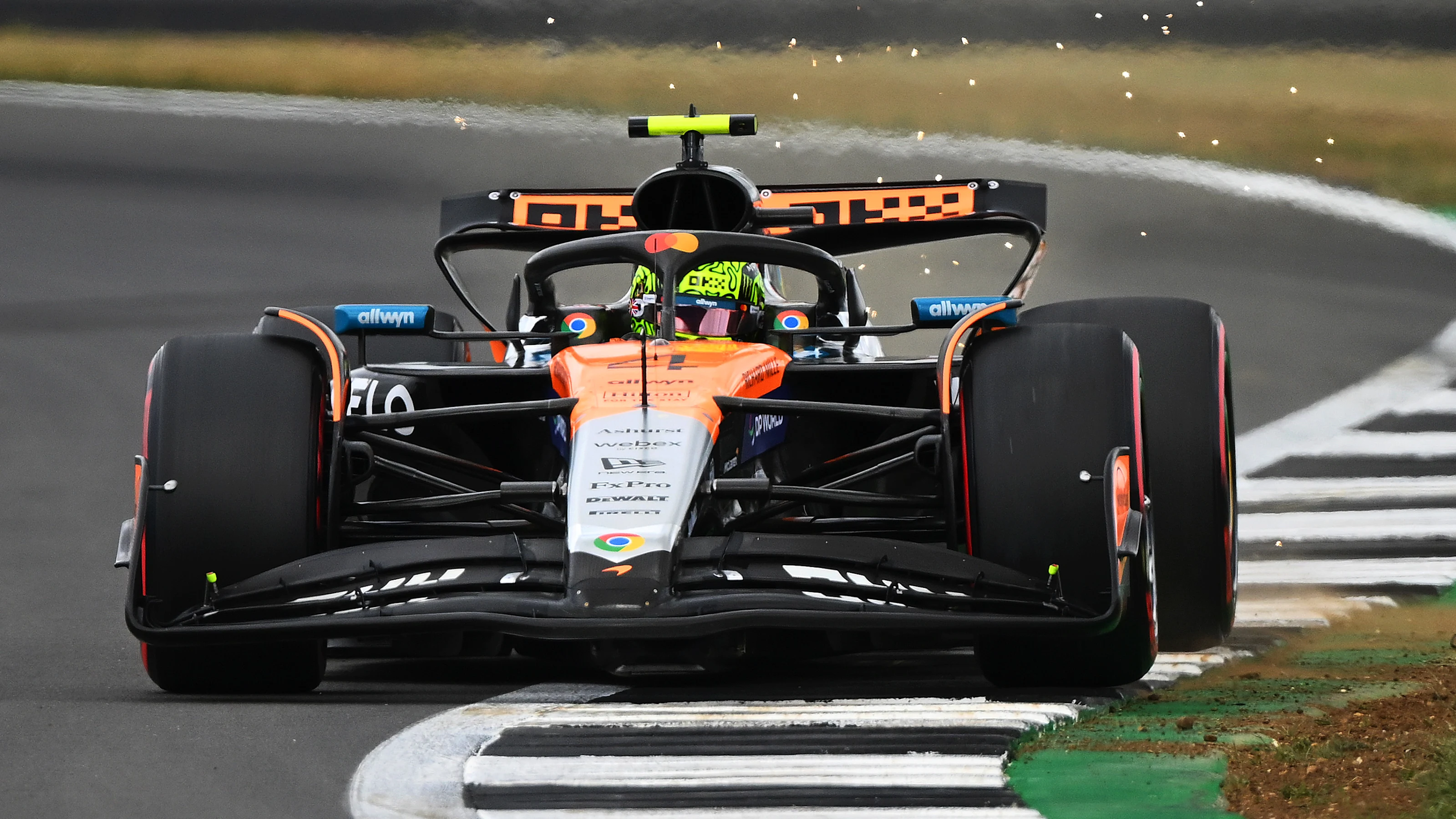 NORTHAMPTON, ENGLAND - JULY 05: Sparks fly behind Lando Norris of Great Britain driving the (4)