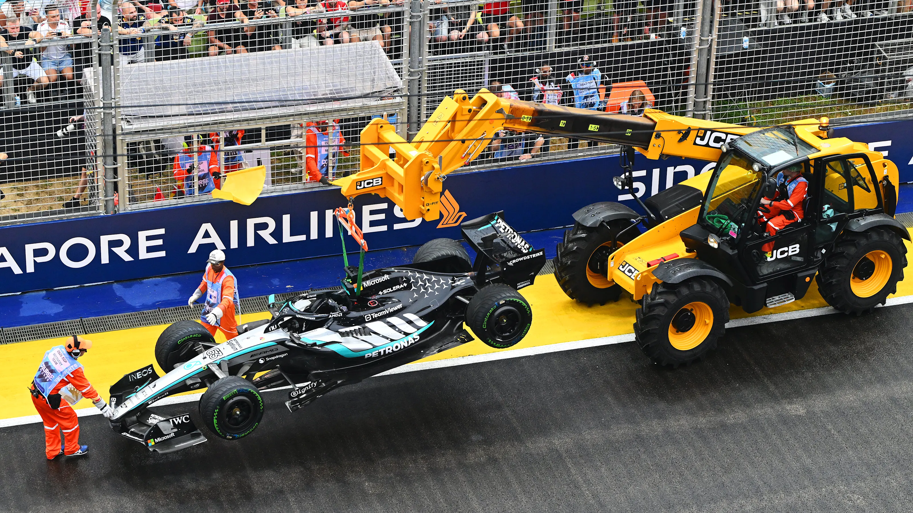SINGAPORE, SINGAPORE - OCTOBER 10: Marshals remove the damaged car of George Russell of Great