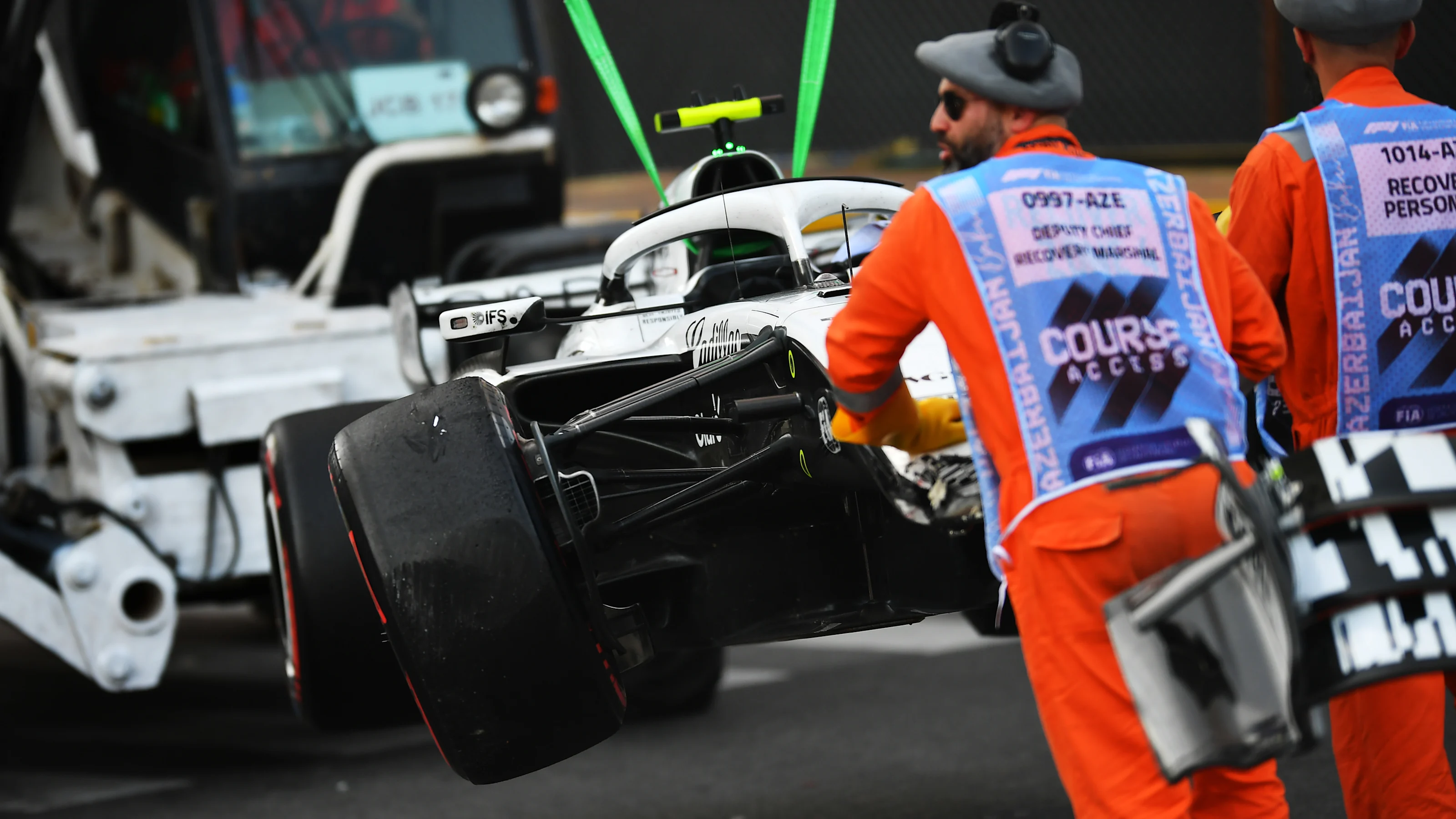 BAKU, AZERBAIJAN - SEPTEMBER 26: Marshals remove the damaged car of Valtteri Bottas of Finland and