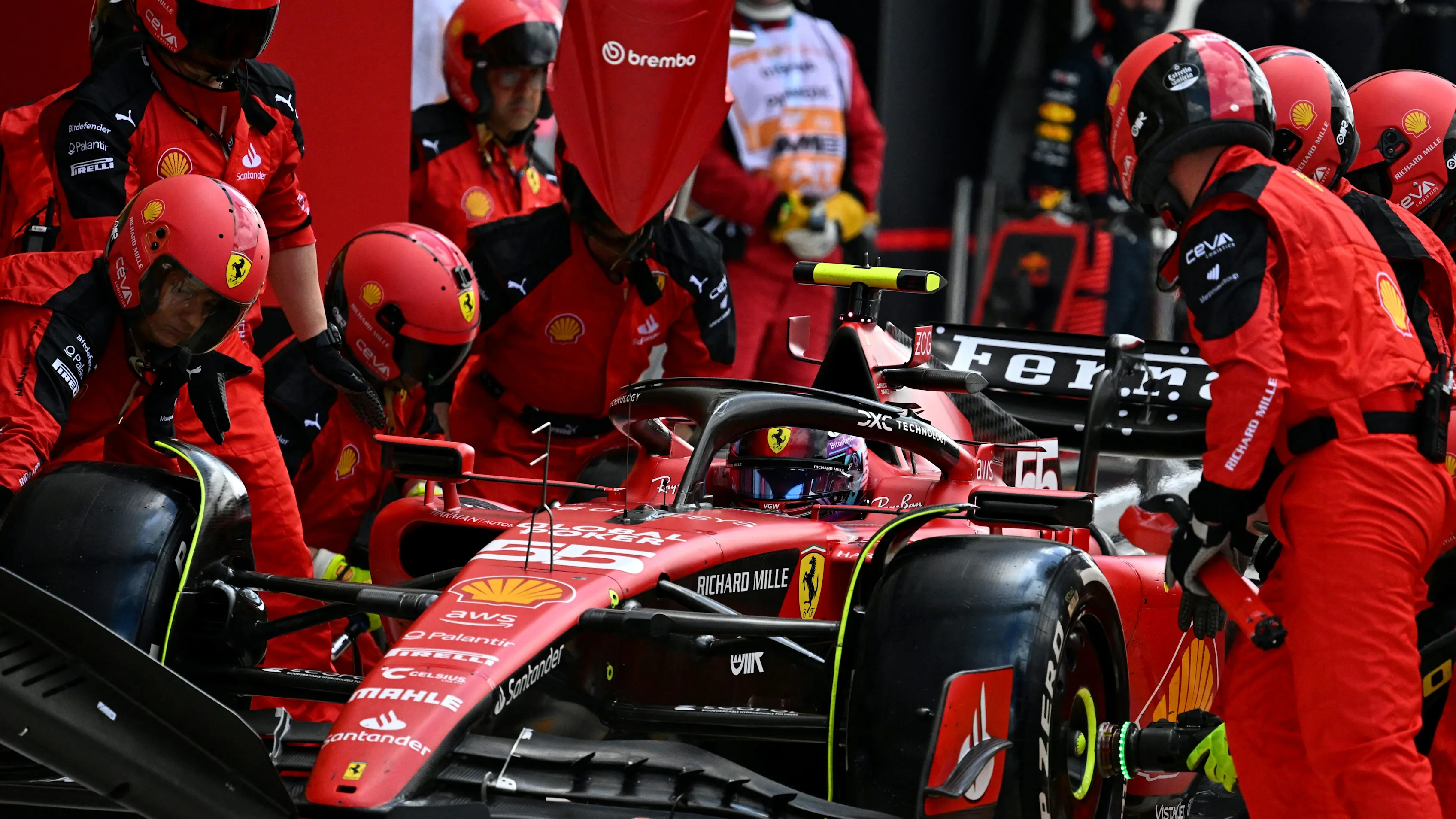 Crew members work on the car of Ferrari's Spanish driver Carlos Sainz Jr. in the pitlane during the