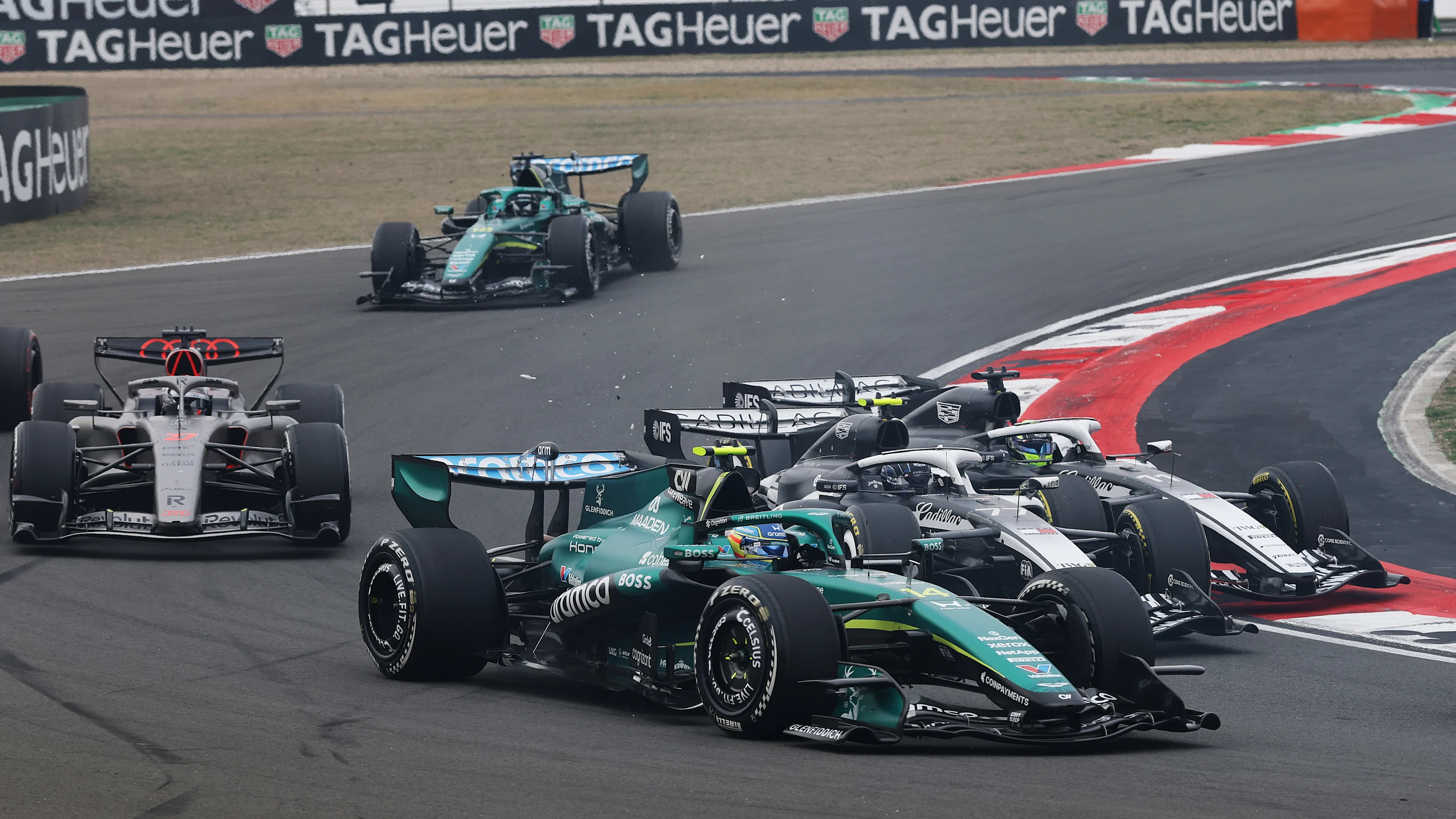 SHANGHAI, CHINA - MARCH 15: Fernando Alonso of Spain driving the (14) Aston Martin F1 Team AMR26 Honda leads as Valtteri Bottas of Finland driving the (77) Cadillac F1 Team MAC-26 Ferrari and Sergio Perez of Mexico driving the (11) Cadillac F1 Team MAC-26 Ferrari collide at the start during the F1 Grand Prix of China at Shanghai International Circuit on March 15, 2026 in Shanghai, China. (Photo by Mark Thompson/Getty Images)