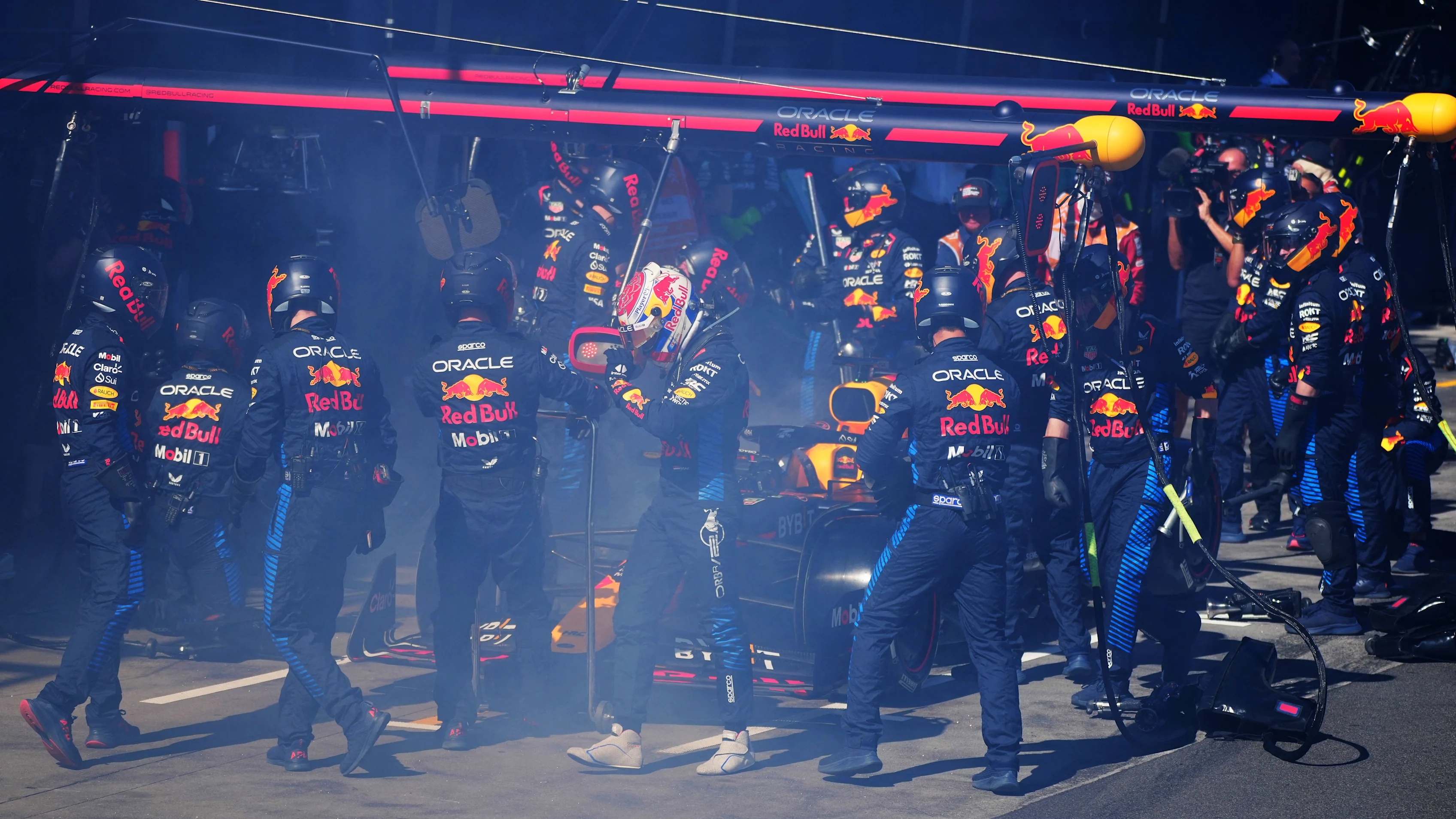 Red Bull Racing's Dutch driver Max Verstappen (C) walks back to the garage after smoke billowing