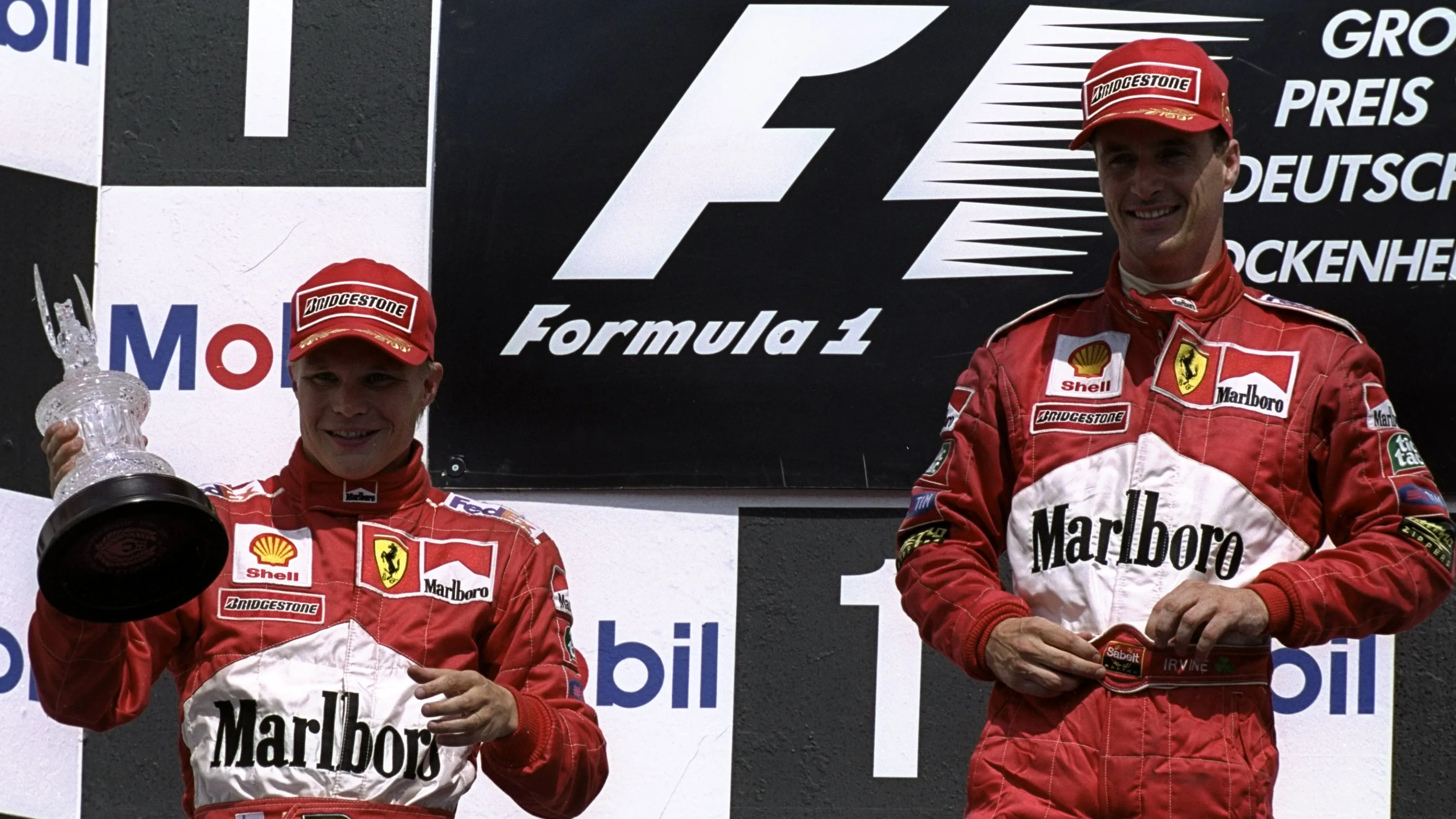 1 Aug 1999:  Ferrari's Mika Salo (L) with his trophy for second place alongside team mate and