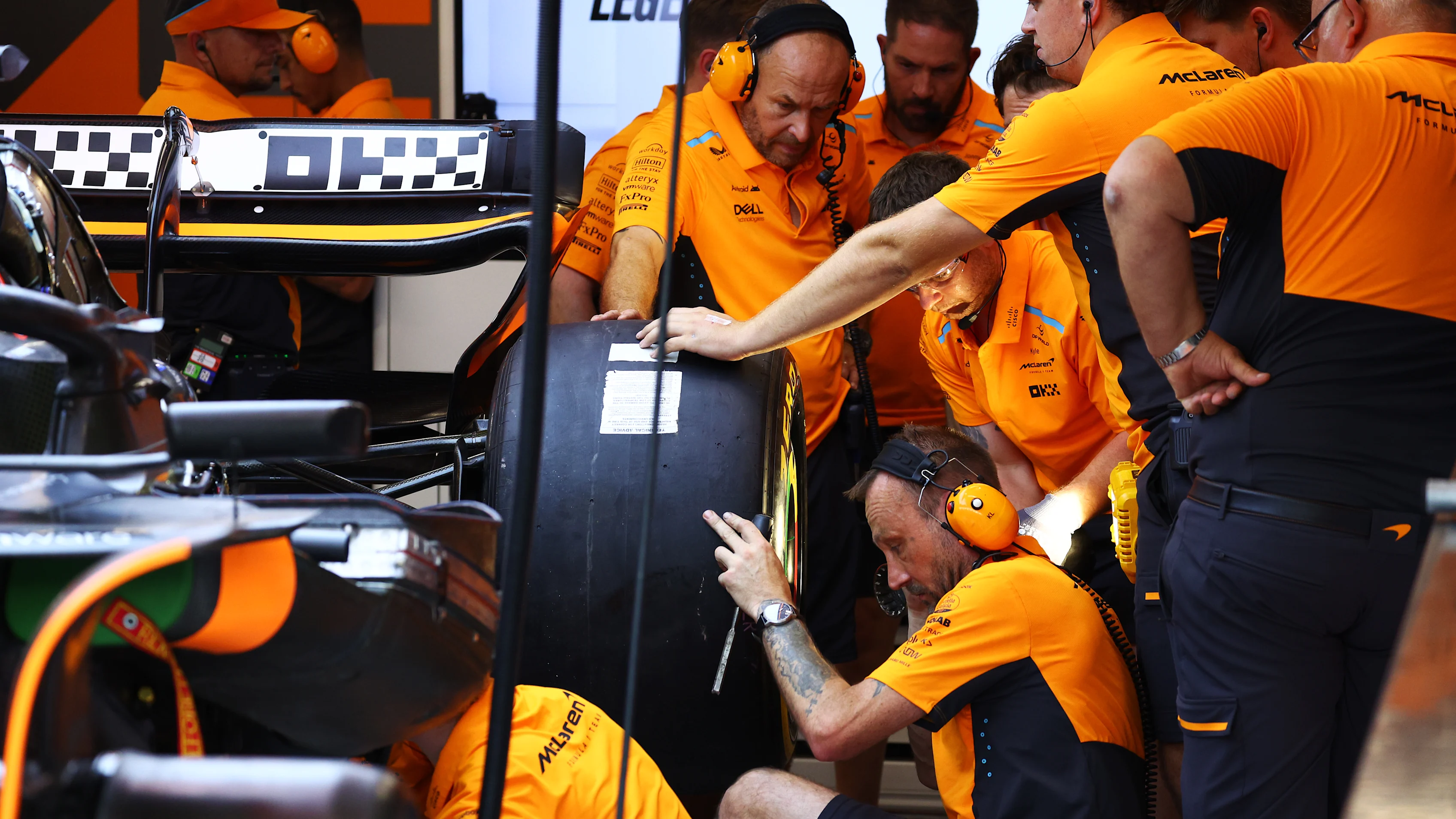 SINGAPORE, SINGAPORE - SEPTEMBER 20: The McLaren team work on the rear wheel of Oscar Piastri of