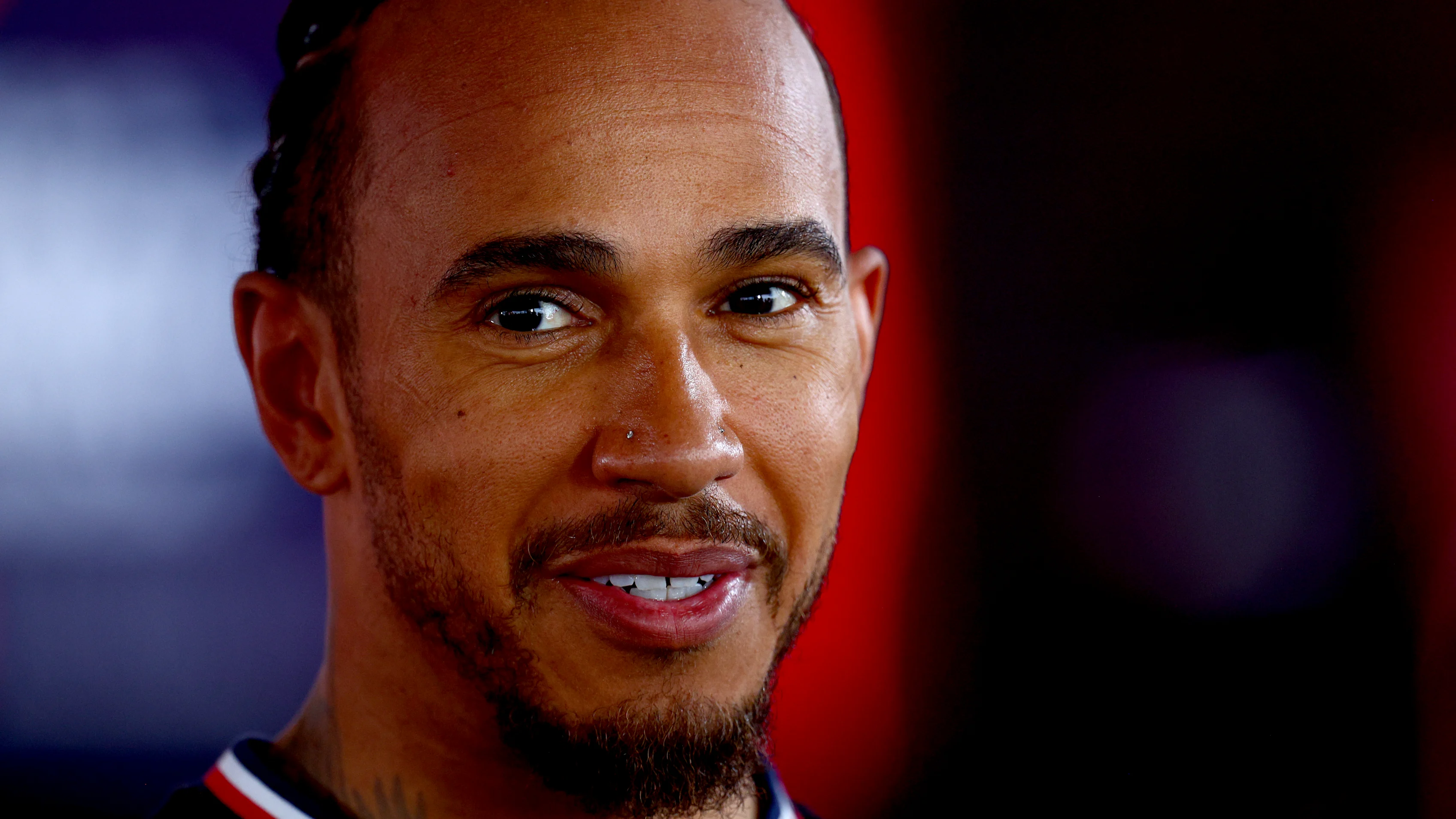 Mercedes' British driver Lewis Hamilton looks on in the stand during the first practice session at