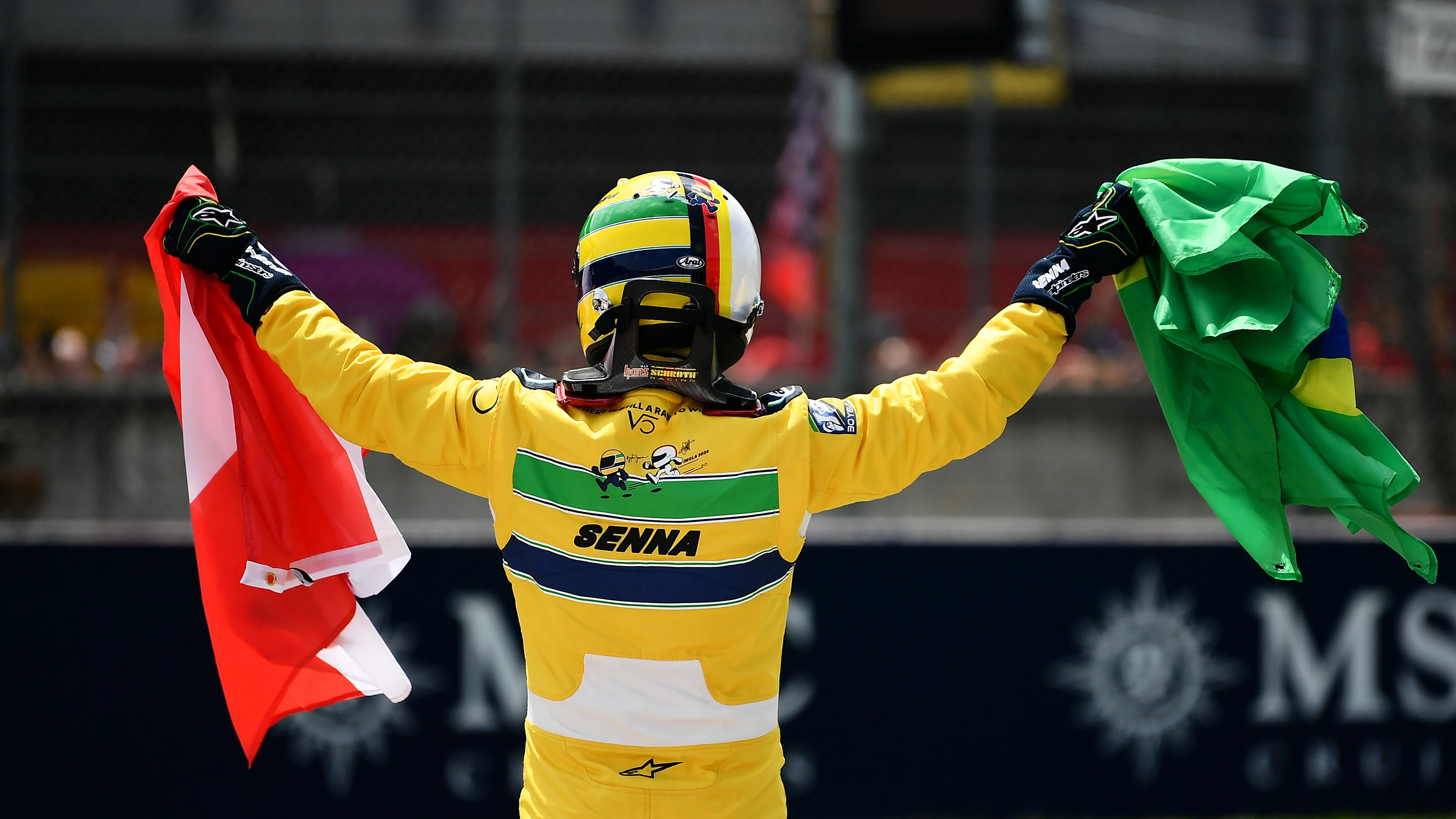 IMOLA, ITALY - MAY 19: Sebastian Vettel holds an Austrian and Brazilian flag in tribute to Roland