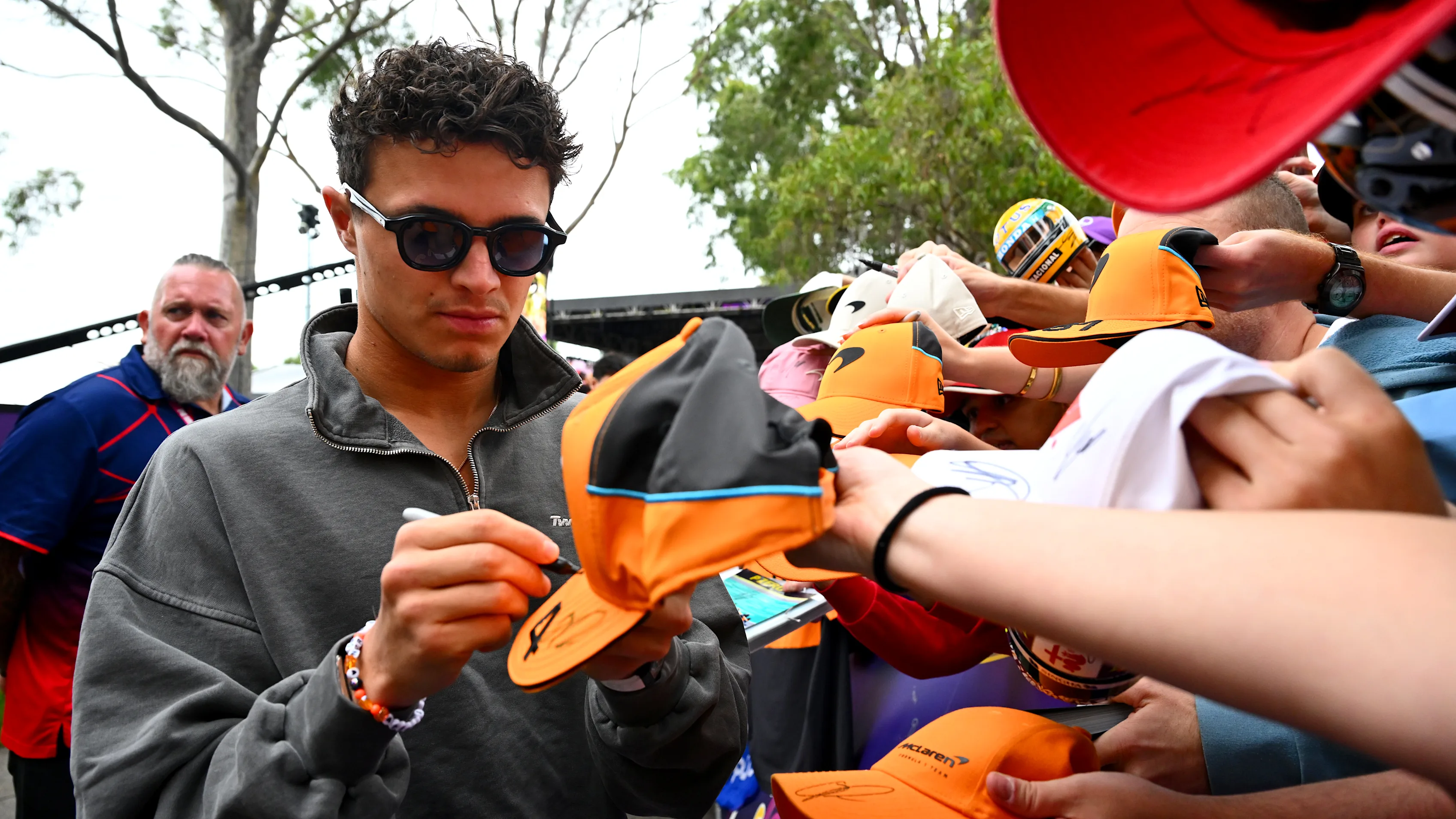 MELBOURNE, AUSTRALIA - MARCH 13: Lando Norris of Great Britain and McLaren signs autographs for
