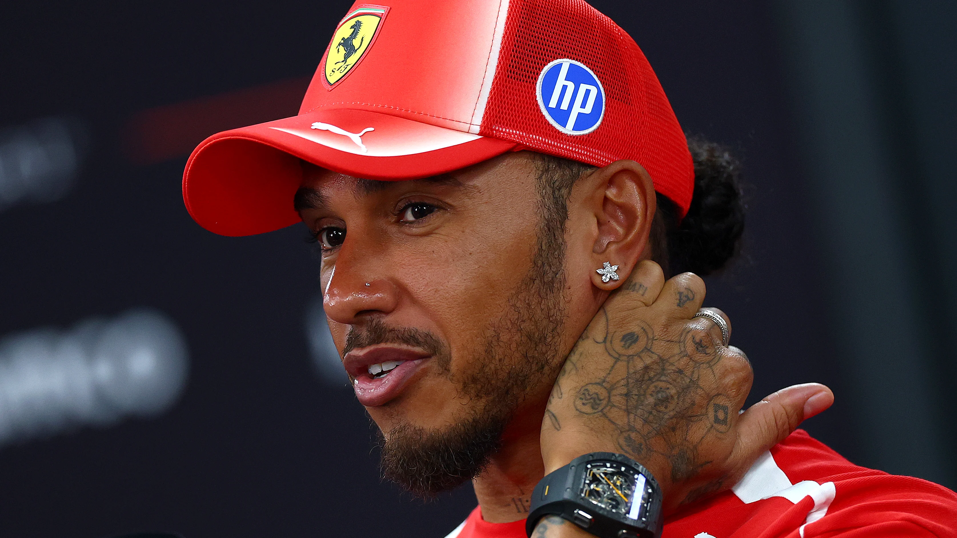 SINGAPORE, SINGAPORE - OCTOBER 08: Lewis Hamilton of Great Britain and Scuderia Ferrari talks to