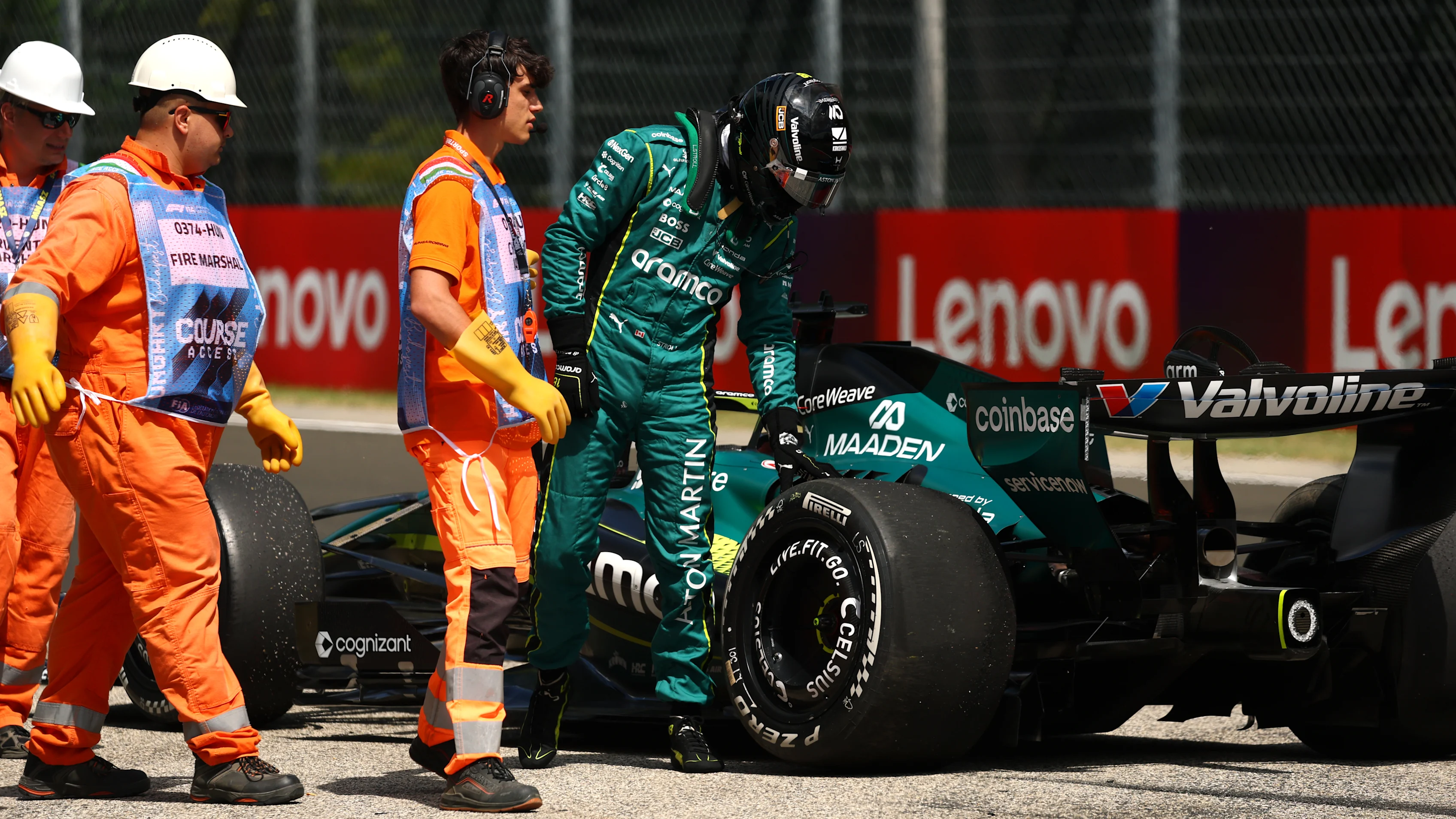 BUDAPEST, HUNGARY - JULY 24: Marshals assist Lance Stroll of Canada and Aston Martin F1 Team during