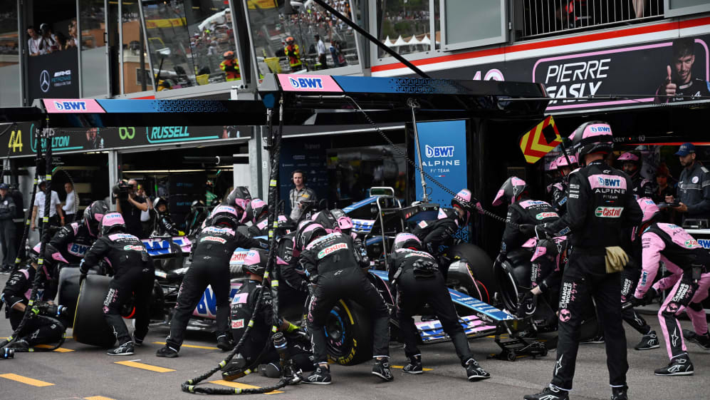 Team members change the wheels   of  Alpine's French driver Esteban Ocon in the pit lane the