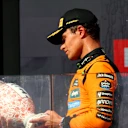 BUDAPEST, HUNGARY - AUGUST 03: Race winner Lando Norris of Great Britain and McLaren inspects his trophy on the podium during the F1 Grand Prix of Hungary at Hungaroring on August 03, 2025 in Budapest, Hungary. (Photo by Clive Rose/Getty Images)