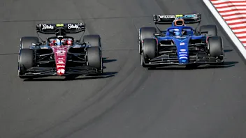 Alfa Romeo's Chinese driver Zhou Guanyu (L) and Williams' US driver Logan Sargeant compete during