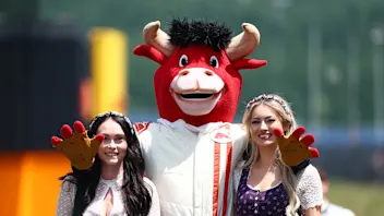 SPIELBERG, AUSTRIA - JUNE 26: The Red Bull mascot with ladies wearing traditional dirndl dresses