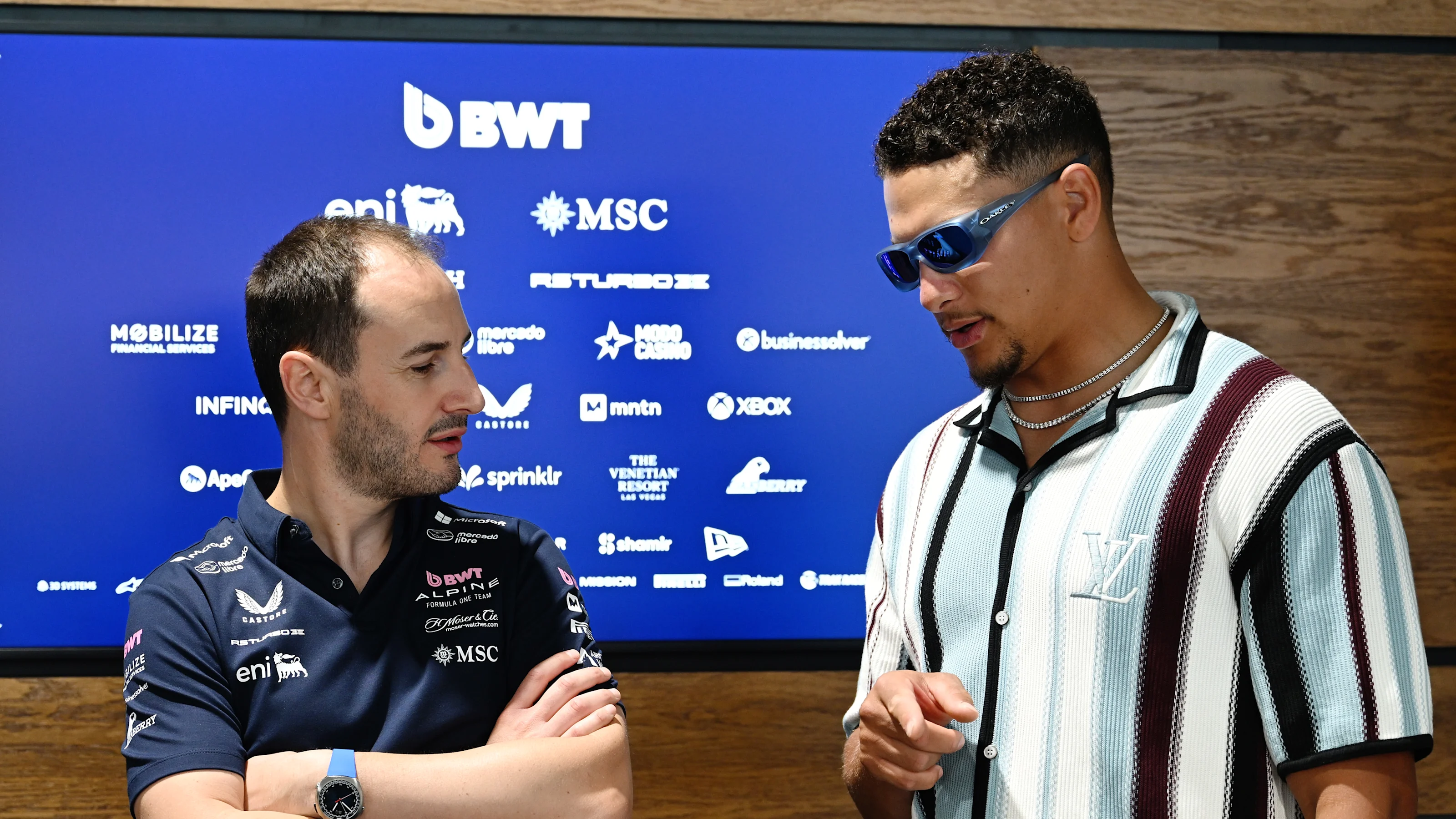 MIAMI, FLORIDA - MAY 04: Oliver Oakes, Team Principal of Alpine F1 talks with NFL player Patrick
