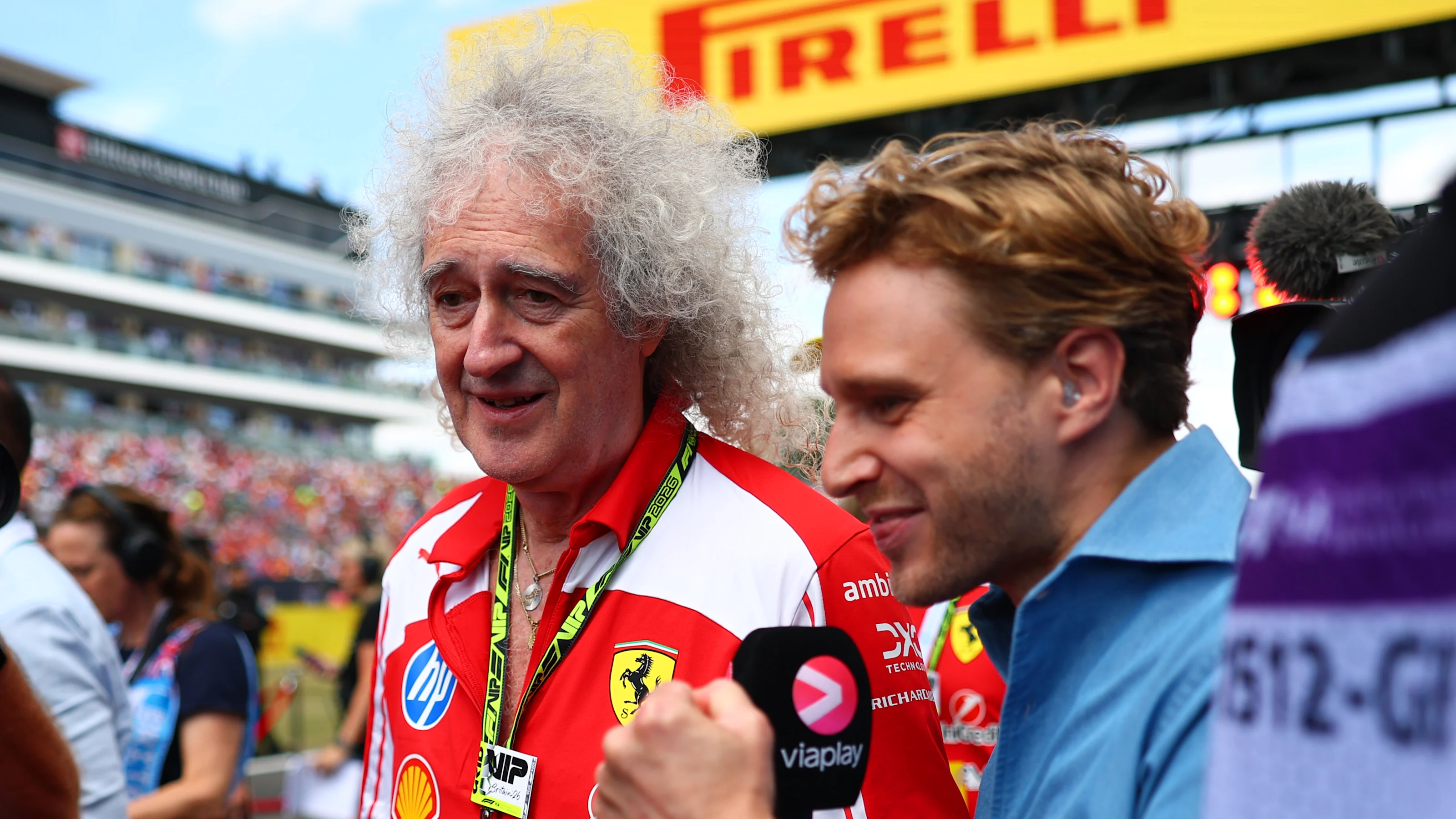 NORTHAMPTON, ENGLAND - JULY 05: Sir Brian May is interviewed on the grid during the F1 Grand Prix