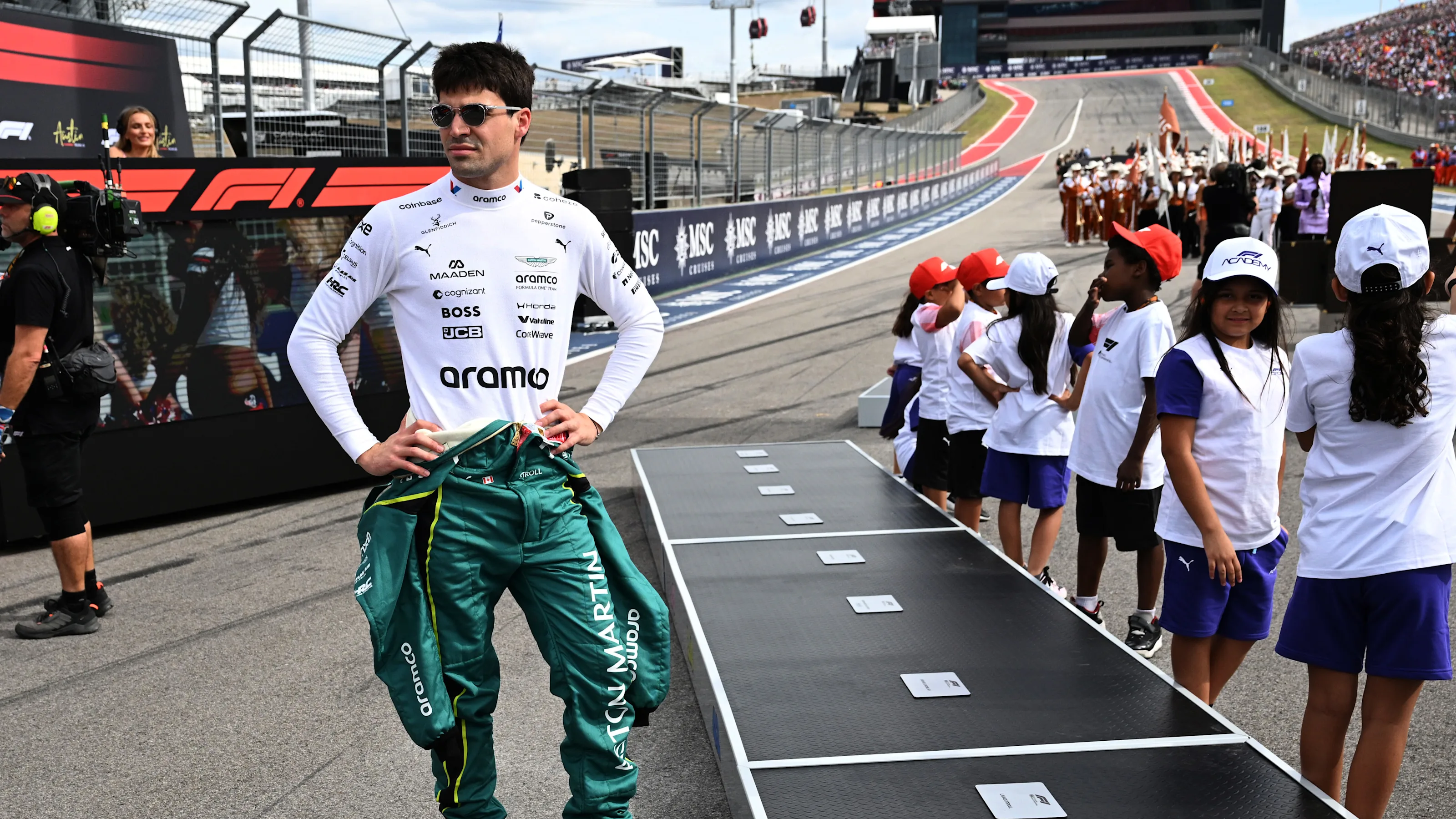 AUSTIN, TEXAS - OCTOBER 25: Lance Stroll of Canada and Aston Martin F1 Team looks on from the grid