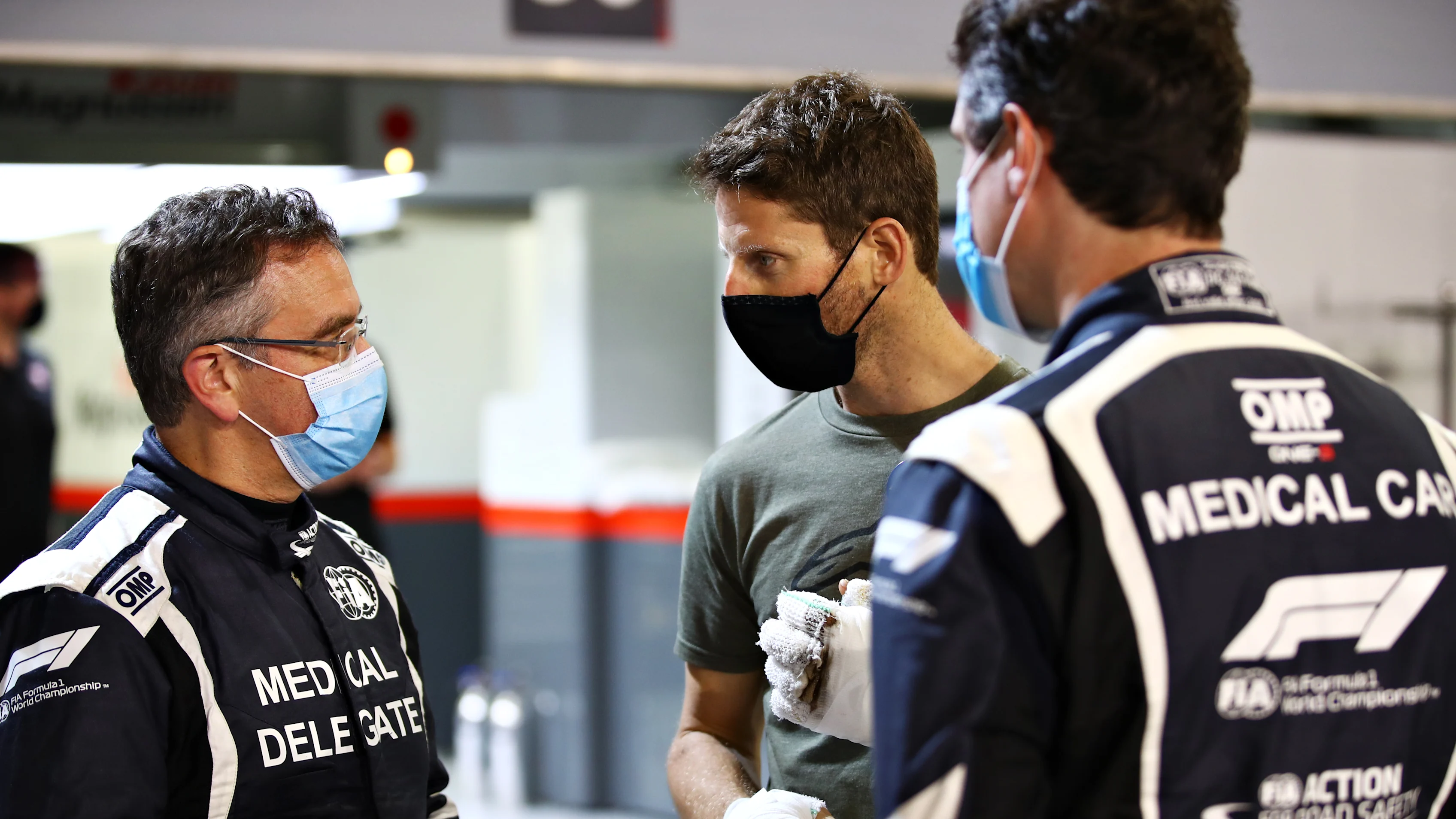 BAHRAIN, BAHRAIN - DECEMBER 03: Romain Grosjean of France and Haas F1 talks with FIA Medical Car