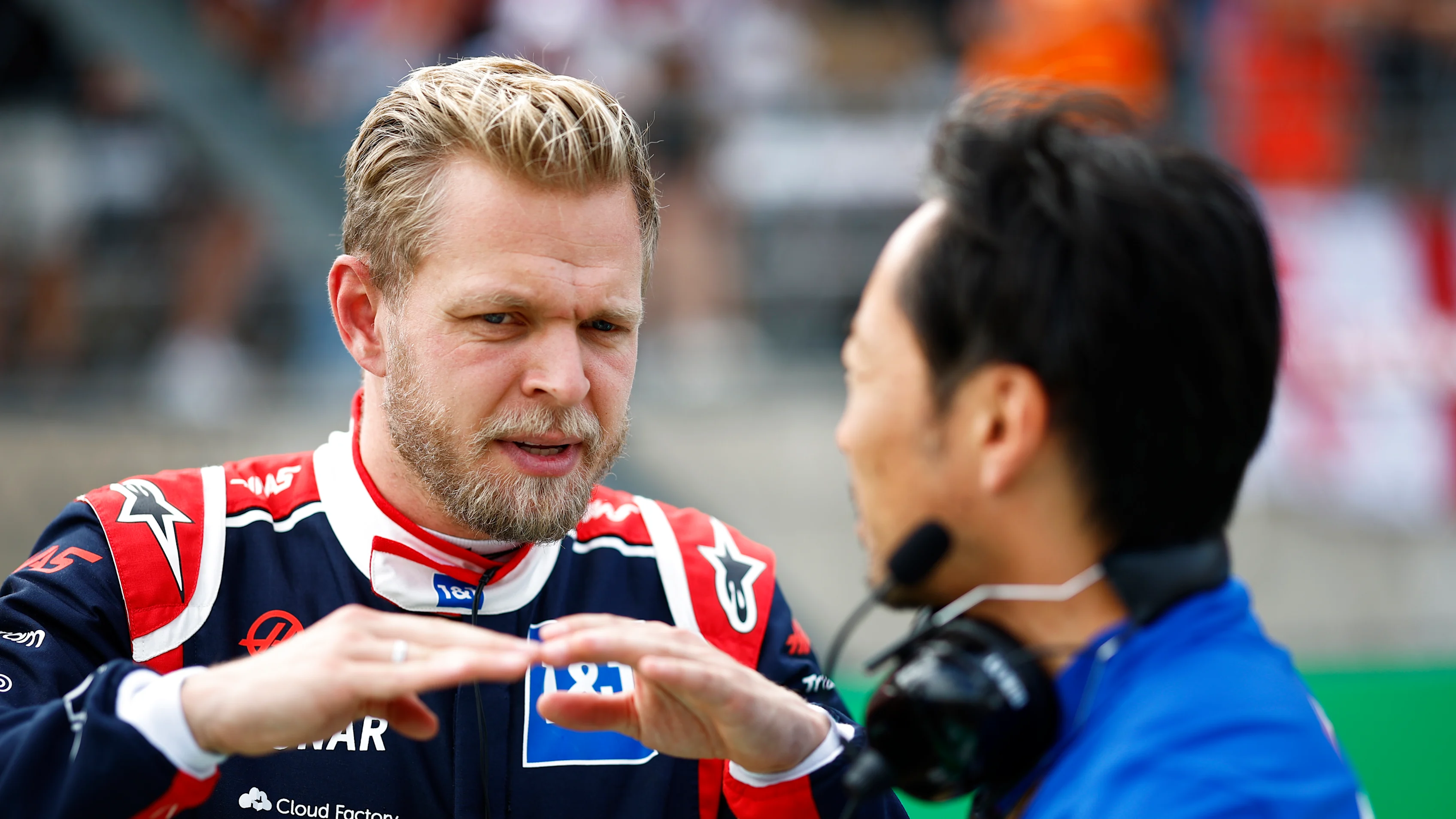AUSTIN, TEXAS - OCTOBER 23: Kevin Magnussen of Denmark and Haas F1 talks with Ayao Komatsu on the