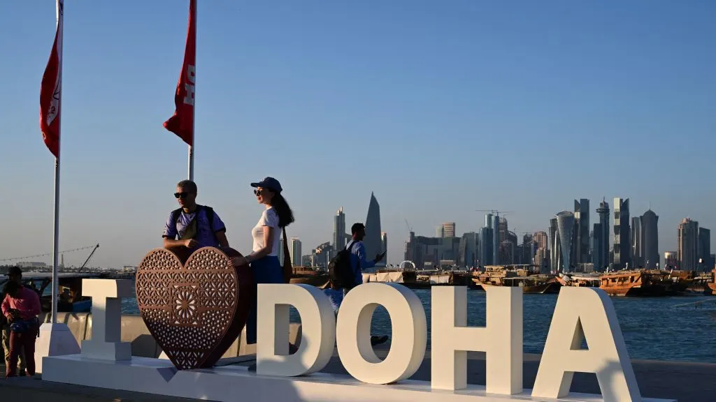 Tourists pose for photos at the Corniche promenade in Doha on November 28, 2022 during the Qatar