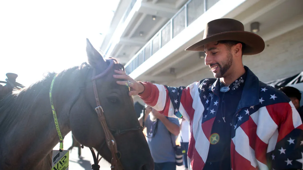 AUSTIN, TEXAS - OCTOBER 20: Daniel Ricciardo of Australia and McLaren pets a horse in the Paddock