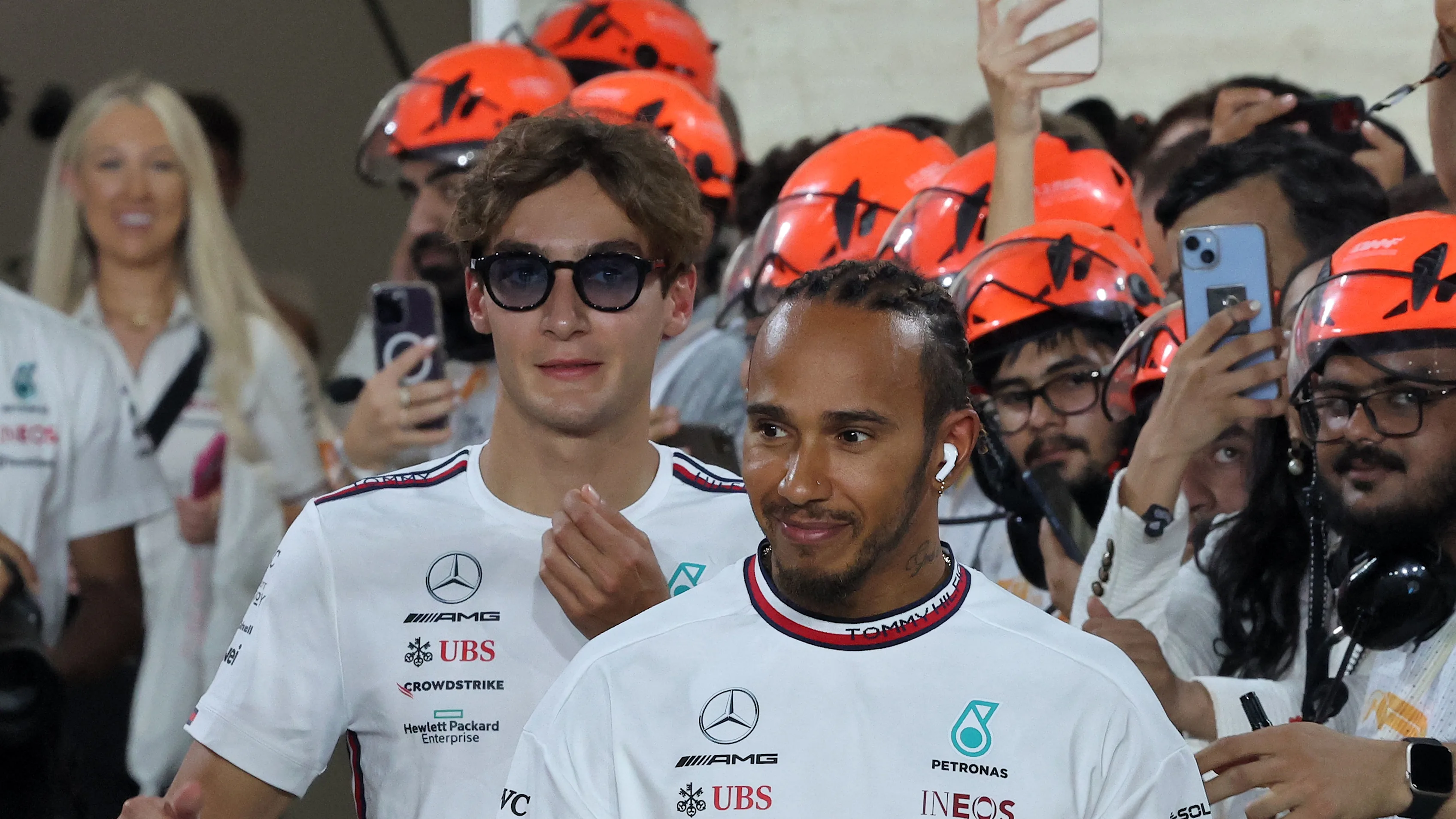 Mercedes' British driver Lewis Hamilton (C) and Mercedes' British driver George Russell (L) walk on