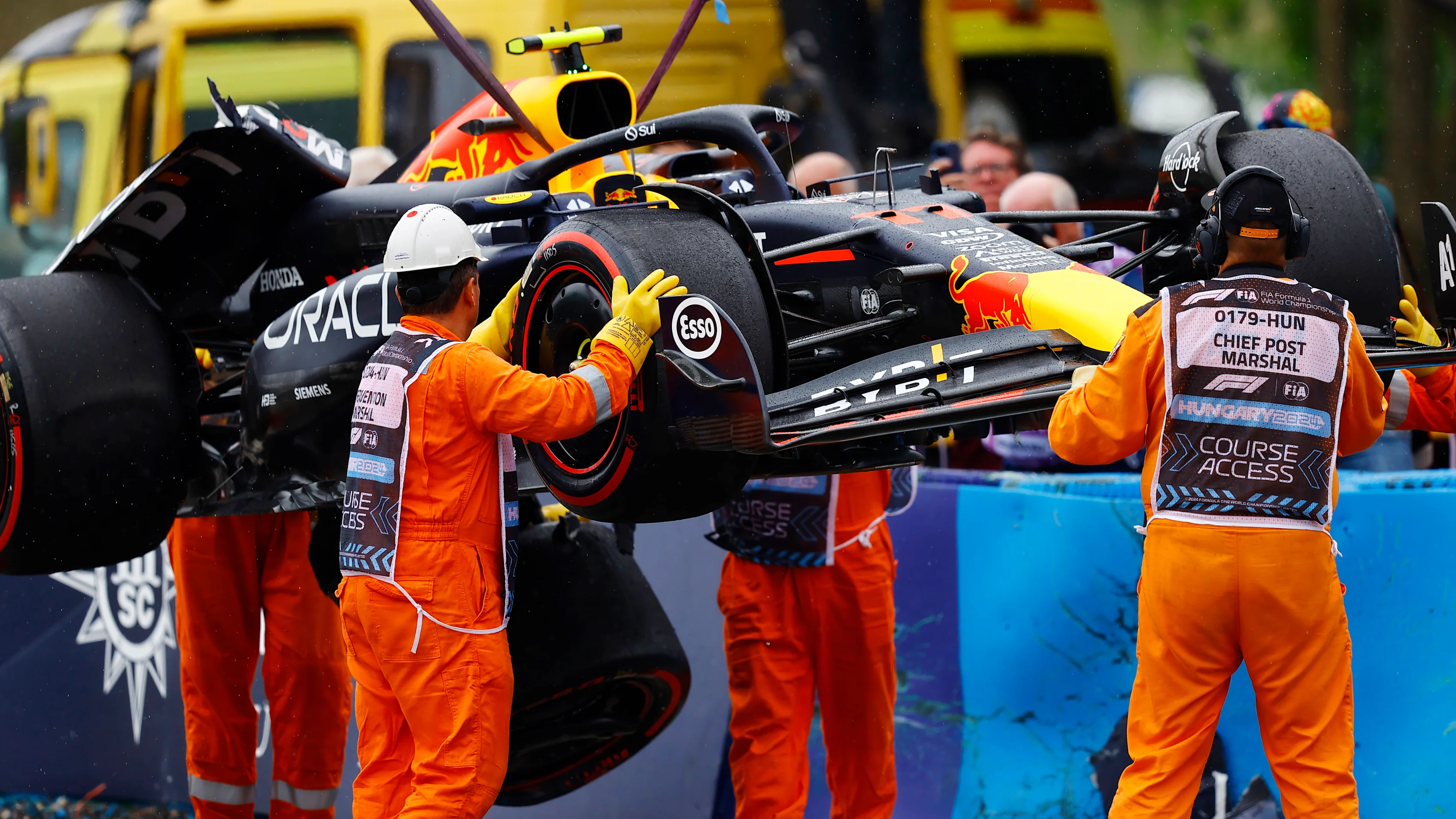 HUNGARORING, HUNGARY - JULY 20: Marshals remove the damaged car of Sergio Perez, Red Bull Racing