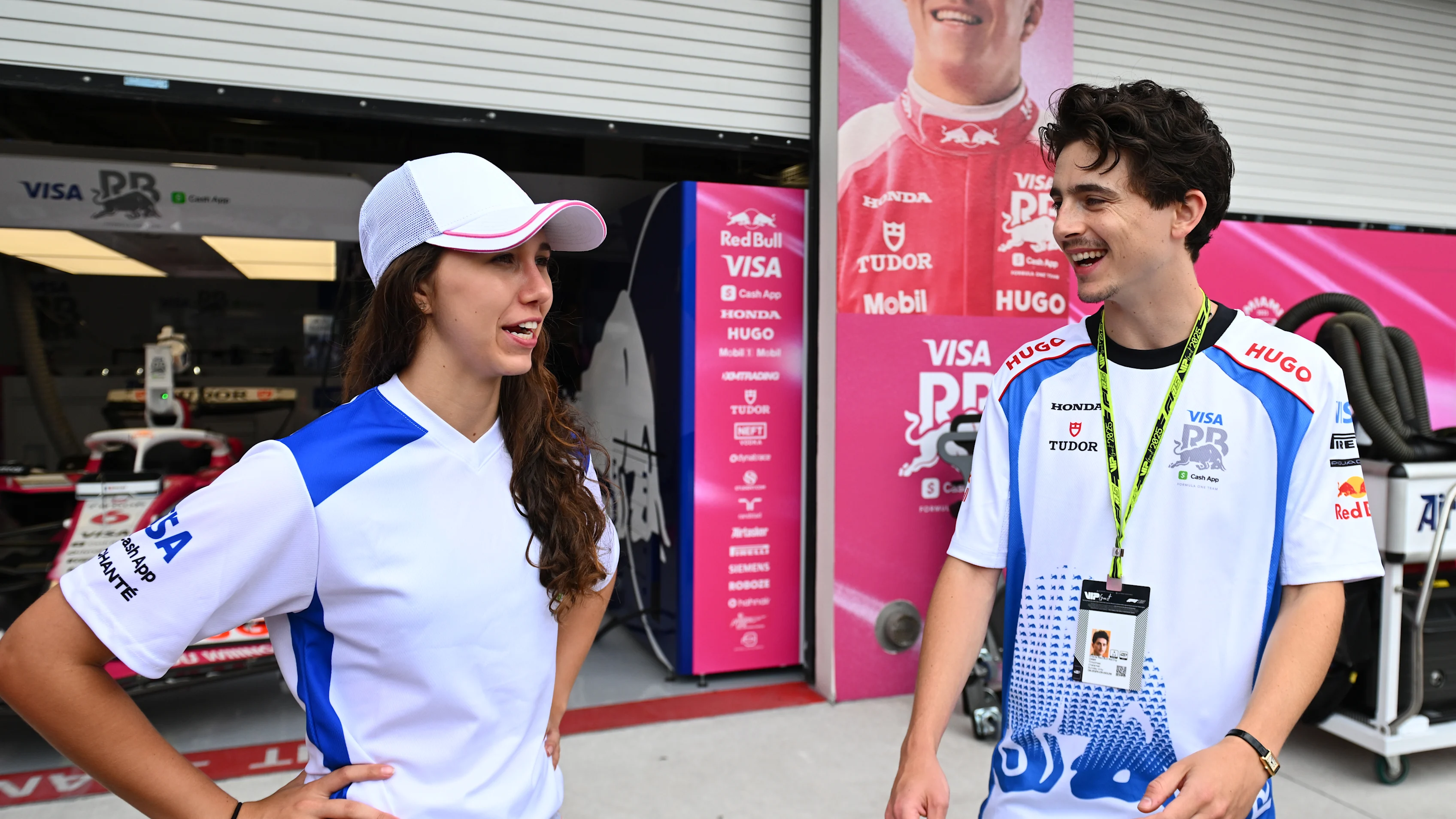 Actor Timothee Chalamet, in a Racing Bulls shirt, chats with Racing Bulls' F1 ACADEMY driver Rafaela Ferreira