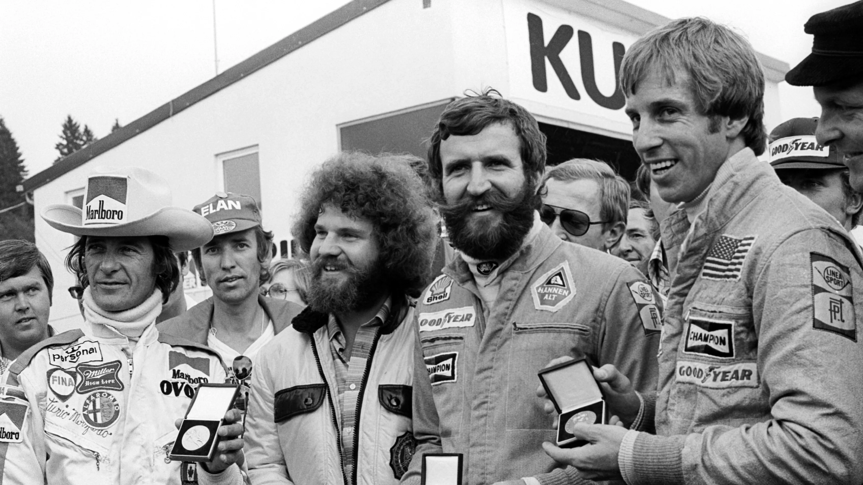 (L to R): Arturo Merzario (ITA) Wolf-Williams; a marshal; Harald Ertl (AUT) Hesketh; and Brett