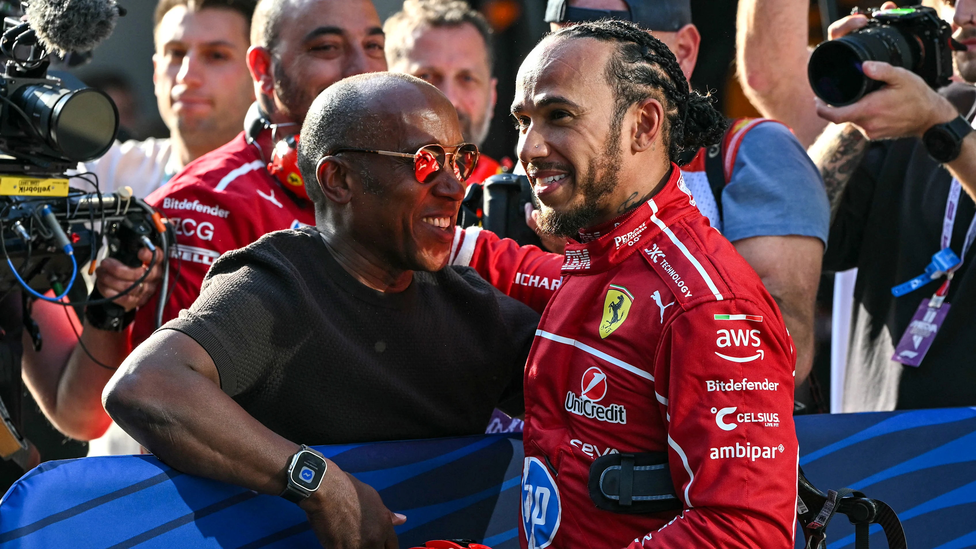 TOPSHOT - Ferrari's British driver Lewis Hamilton (centre R) celebrates taking pole position with