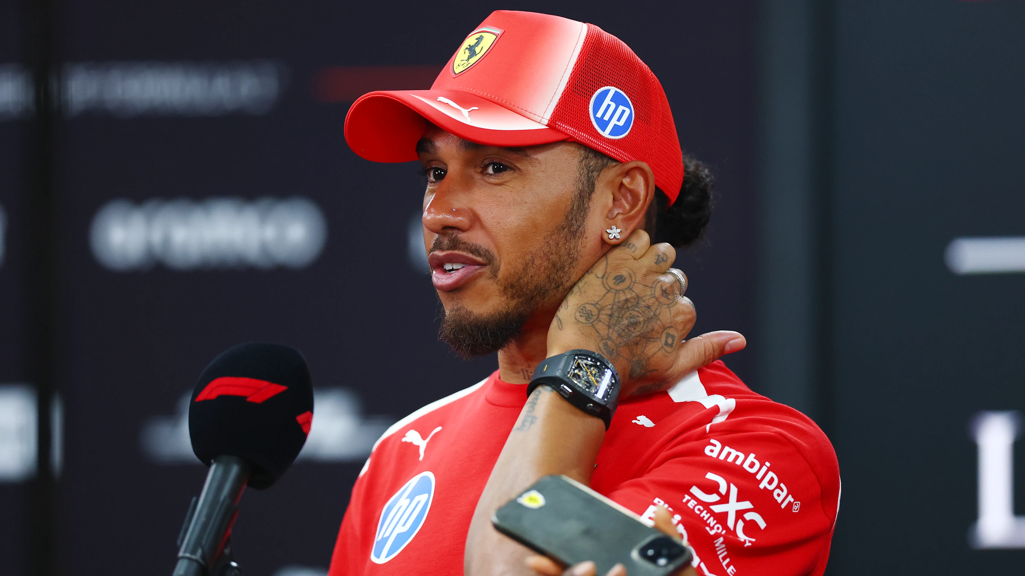 SINGAPORE, SINGAPORE - OCTOBER 08: Lewis Hamilton of Great Britain and Scuderia Ferrari talks to