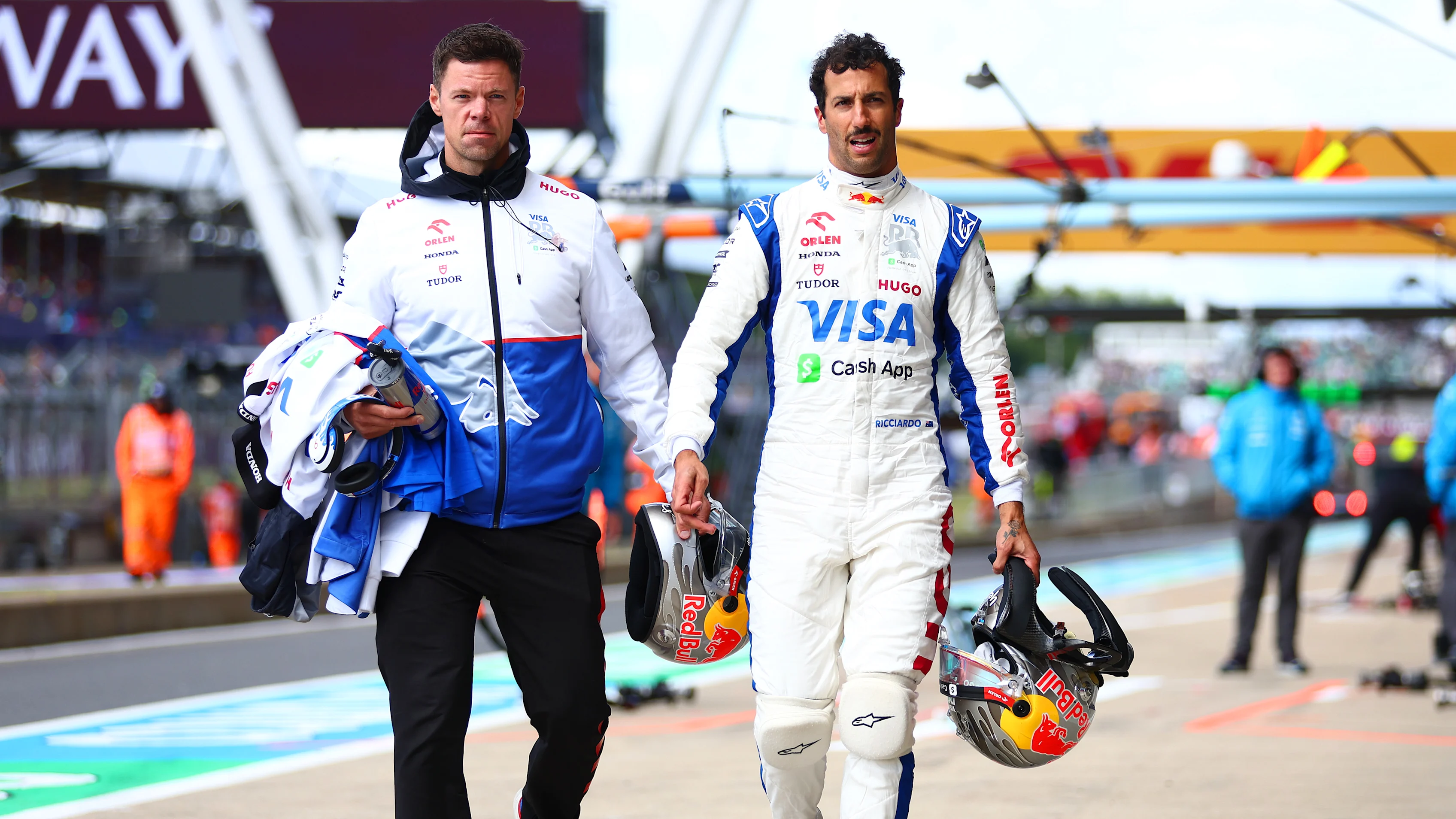 NORTHAMPTON, ENGLAND - JULY 06: 15th placed qualifier Daniel Ricciardo of Australia and Visa Cash App RB walks in the Pitlane during qualifying ahead of the F1 Grand Prix of Great Britain at Silverstone Circuit on July 06, 2024 in Northampton, England. (Photo by Bryn Lennon - Formula 1/Formula 1 via Getty Images)