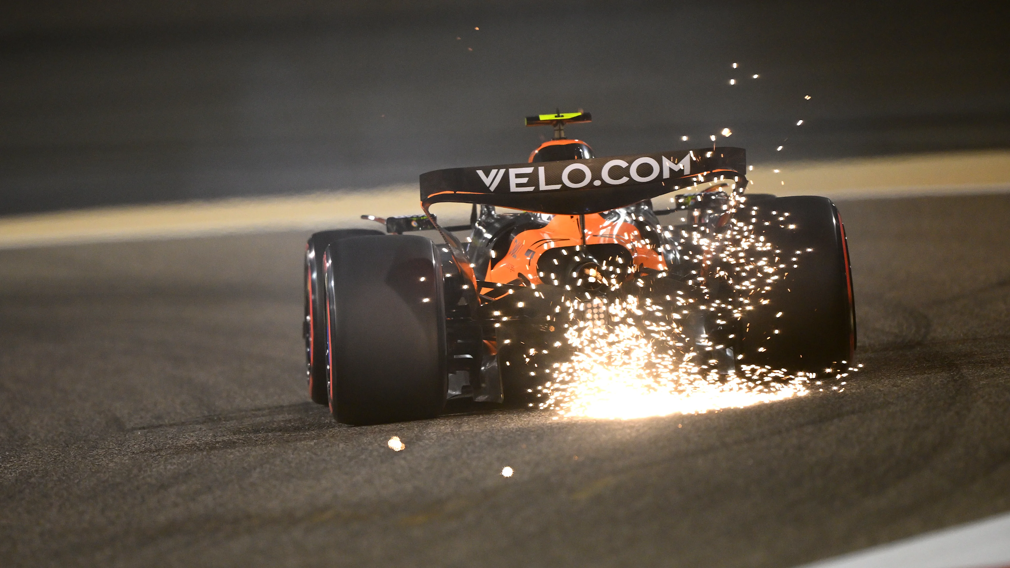 BAHRAIN, BAHRAIN - APRIL 11: Sparks fly behind Lando Norris of Great Britain driving the (4)