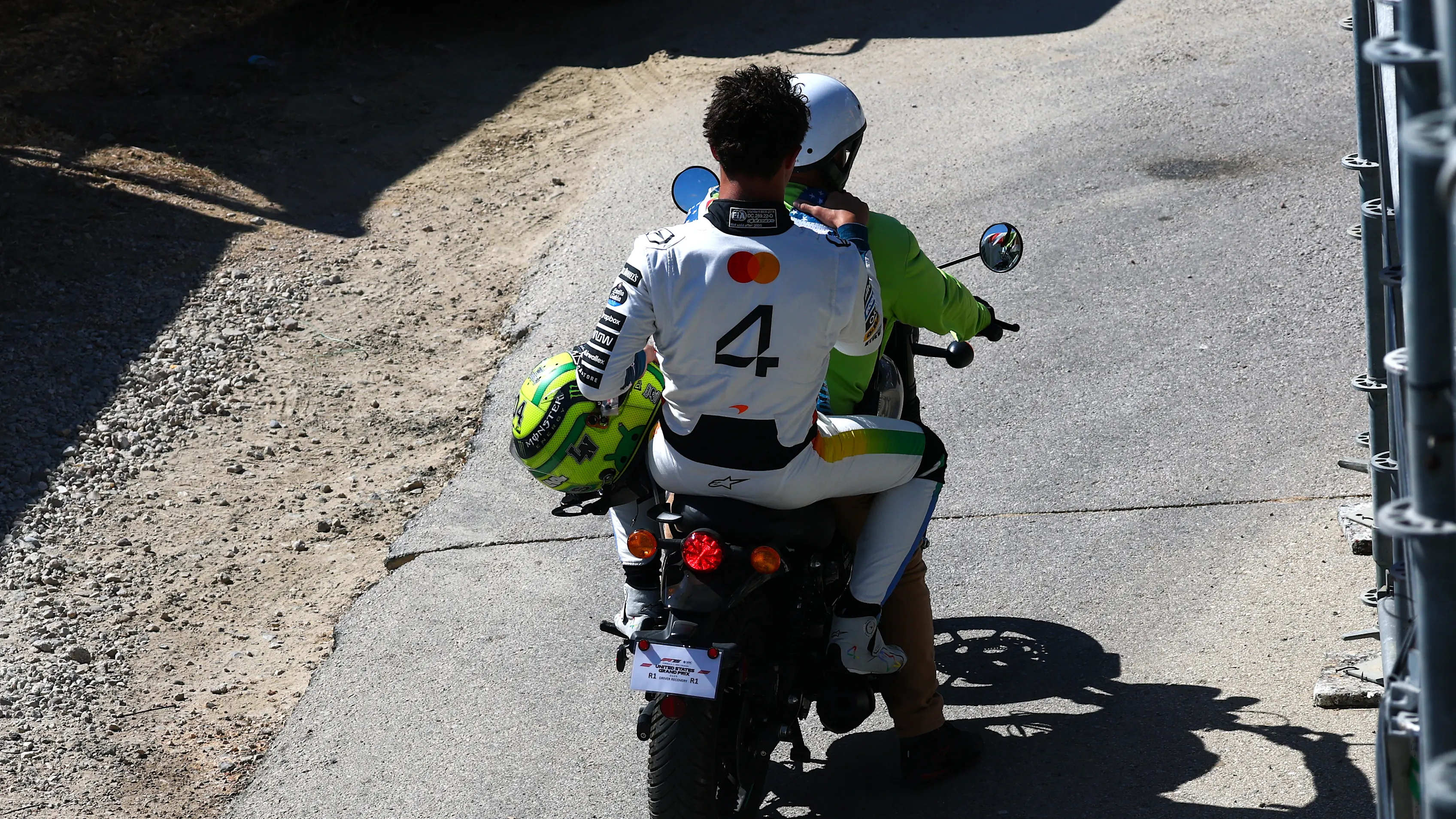 AUSTIN, TEXAS - OCTOBER 18: Lando Norris of Great Britain and McLaren on the back of a moped during the Sprint ahead of the F1 Grand Prix of United States at Circuit of The Americas on October 18, 2025 in Austin, Texas. (Photo by Mark Thompson/Getty Images)
