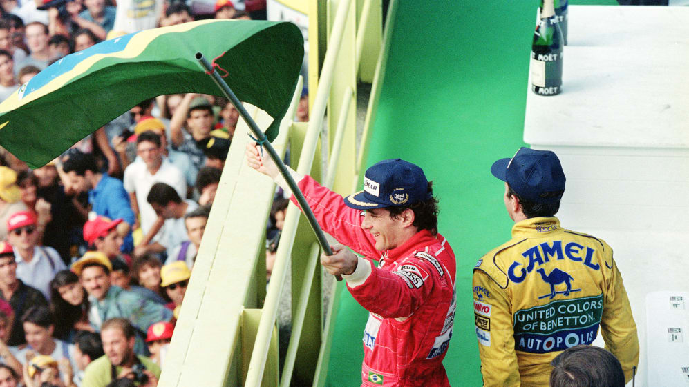 Brazilian Formula One driver Ayrton Senna (McLaren-Honda) holds a Brazilian flag and waves to the