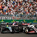 MIAMI, FLORIDA - MAY 05: Nico Hulkenberg of Germany driving the (27) Haas F1 VF-24 Ferrari and Lewis Hamilton of Great Britain driving the (44) Mercedes AMG Petronas F1 Team W15 battle for position on track during the F1 Grand Prix of Miami at Miami International Autodrome on May 05, 2024 in Miami, Florida. (Photo by Chris Graythen/Getty Images)