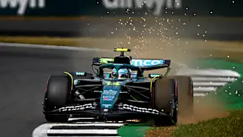 NORTHAMPTON, ENGLAND - JULY 05: Sparks fly behind Fernando Alonso of Spain driving the (14) Aston